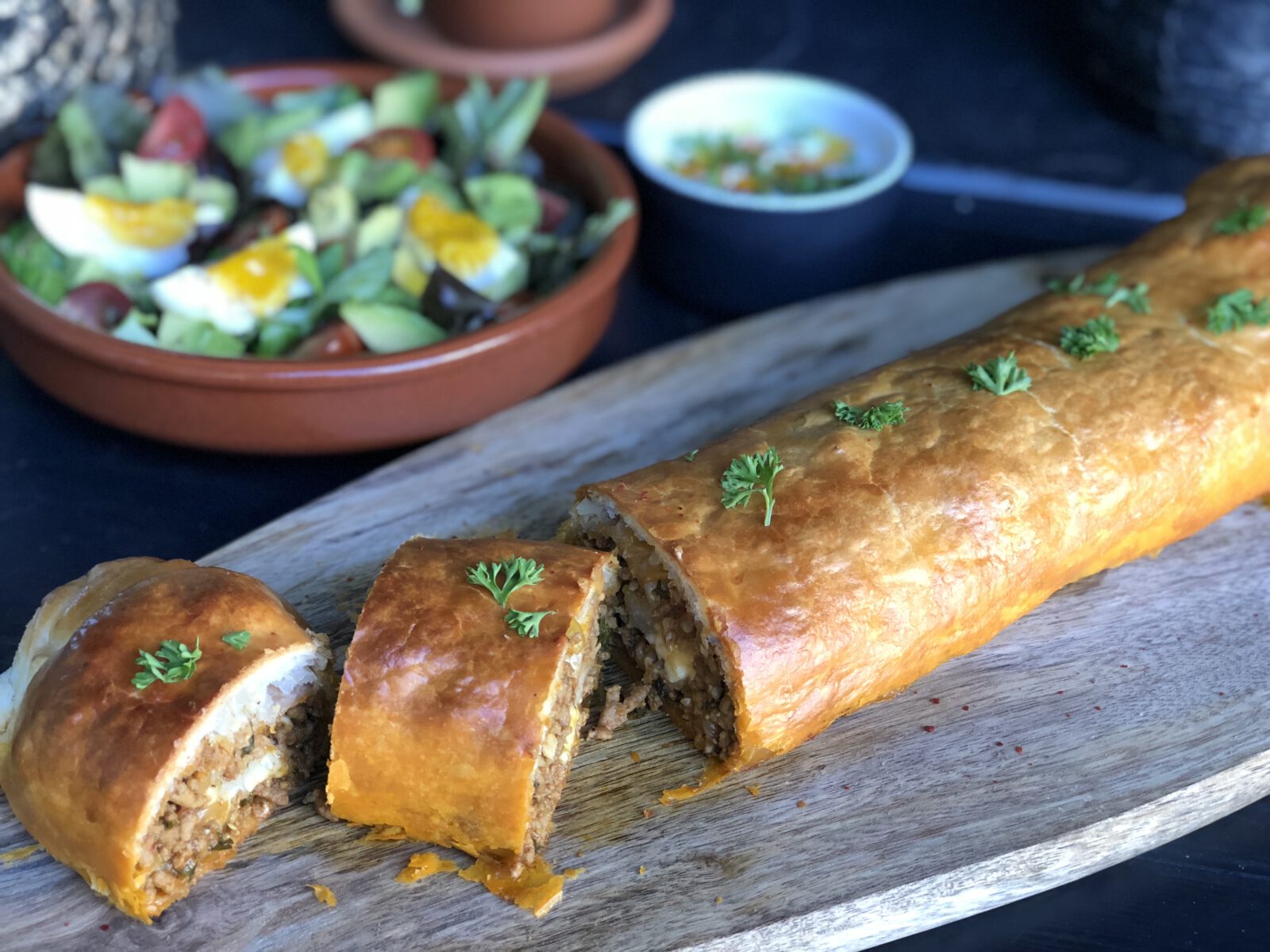 Bladerdeeg rol gevuld met pittig gehakt en kaas