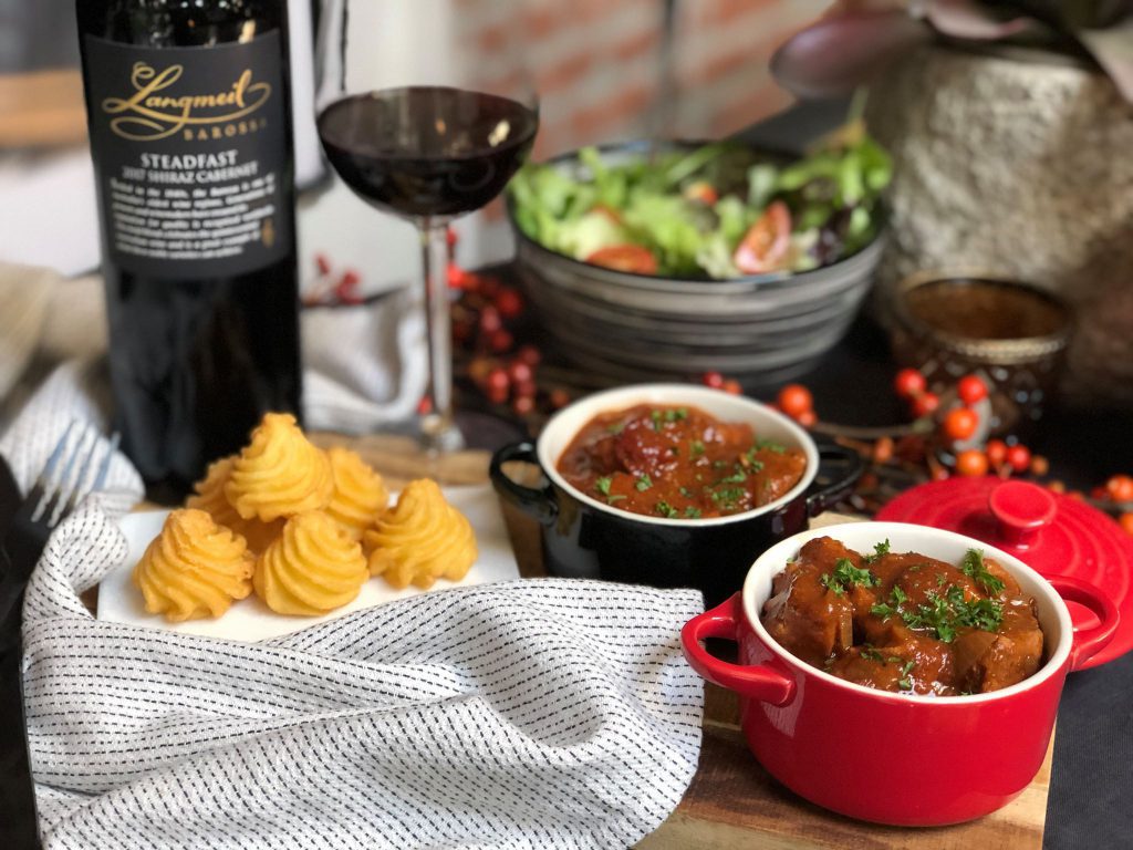 Kip in  rode wijn gestoofd. Serveer met pommes duchesse en een frisse salade.