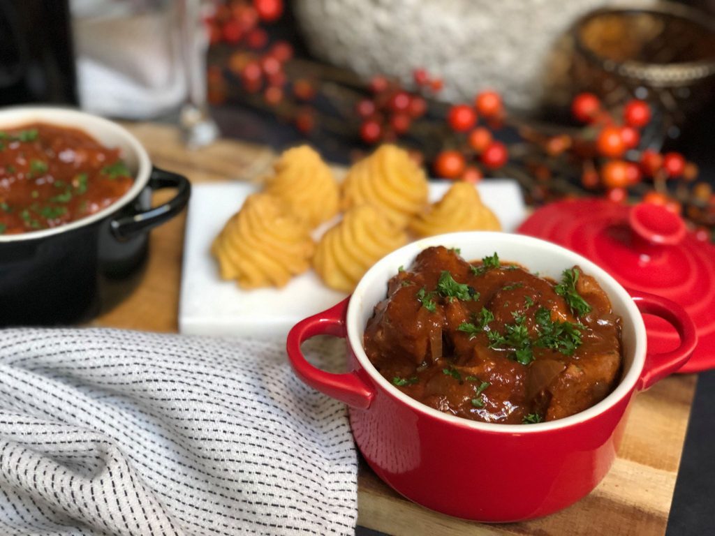 Kip in  rode wijn gestoofd. Serveer met pommes duchesse en een goed glas rode wijn.