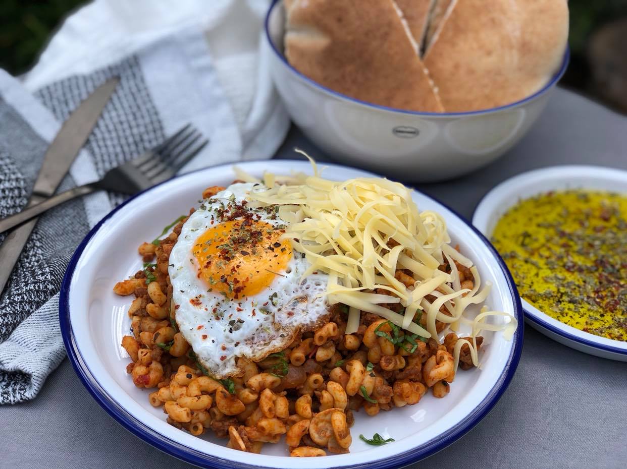 macaroni met gehakt en tomatenpuree geserveerd met kaas en gebakken ei