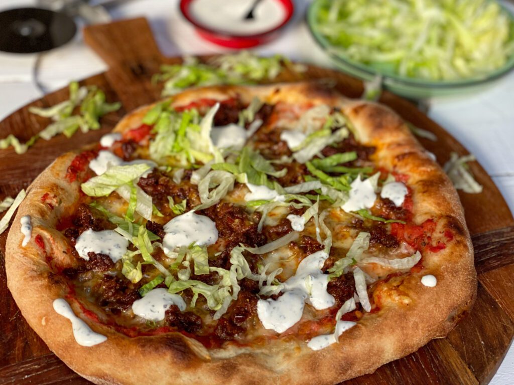 pizza met pittig gehakt, ijsbergsla en frisse saus