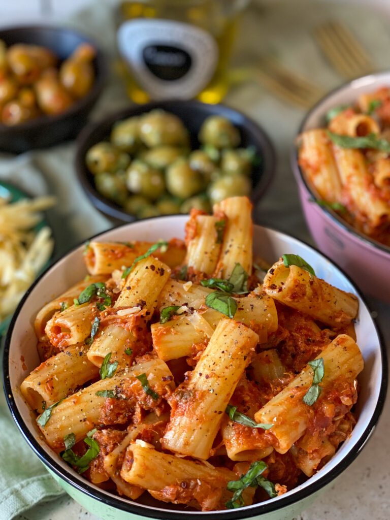 pasta met tonijn in tomatensaus recept – rigatoni geserveerd met verse basilicum