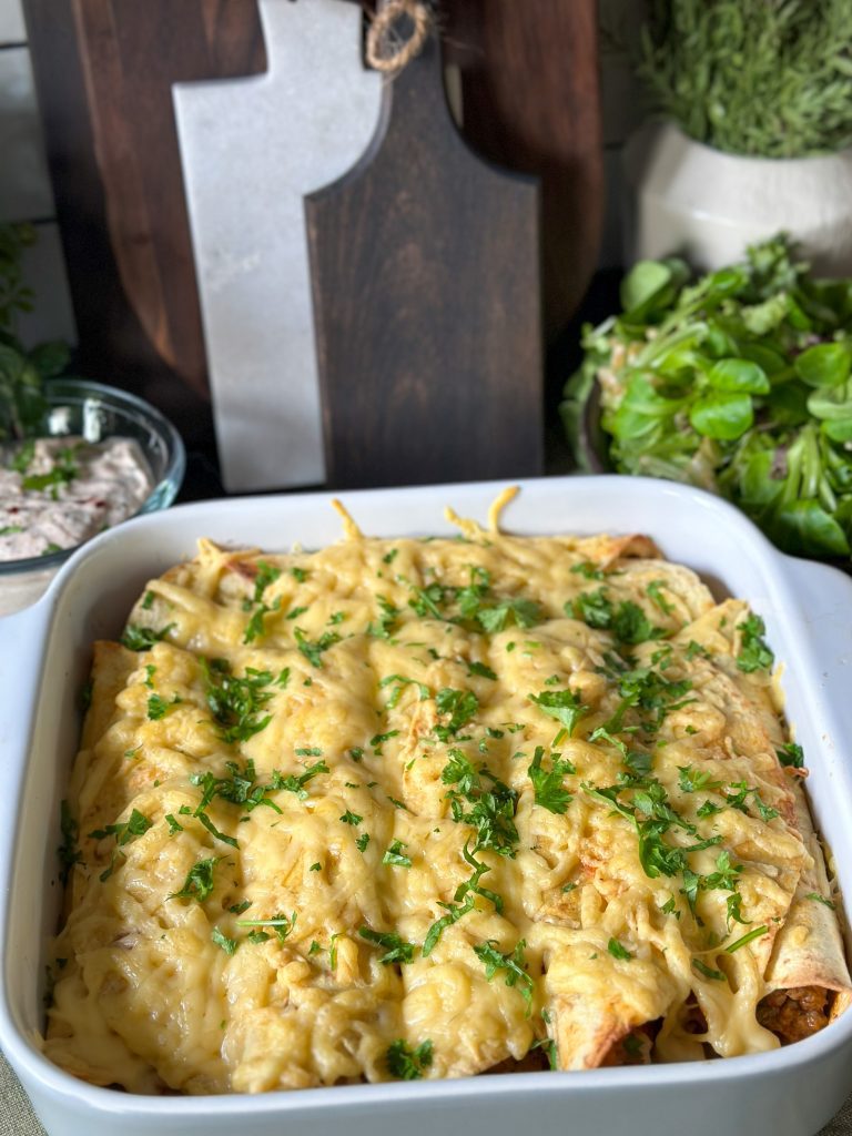 wraps met kruidig gehakt uit de oven, geserveerd met gesmolten kaas in witte ovenschaal en verse peterselie als topping.