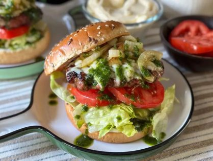 burgers met gebakken uien en geserveerd met een kruidenolie en tomaat