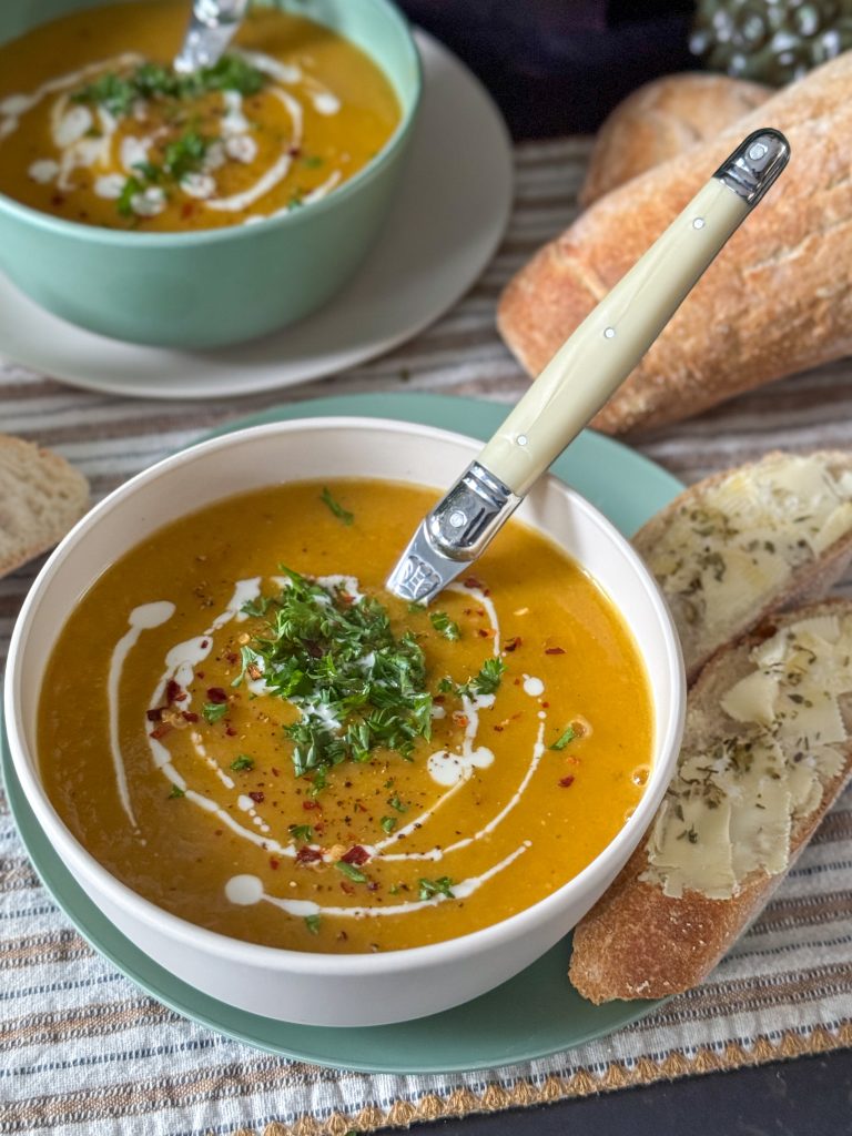 zoete aardappelsoep met prei in witte kom