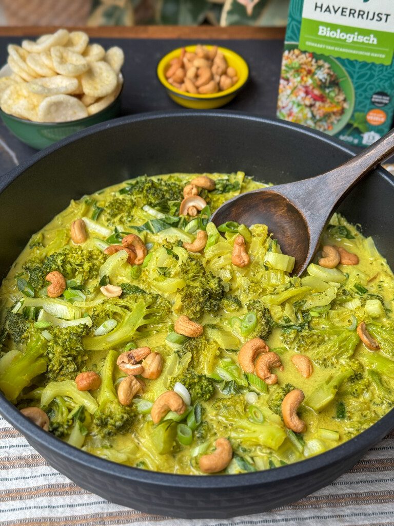 Een pan met romige groente Thaise curry vol groenten zoals broccoli en paksoi.