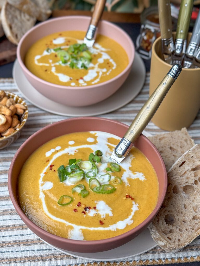 bloemkoolsoep met gele curry, kokosmelk en zoete aardappel. Afgetopt met bosui en chilivlokken
