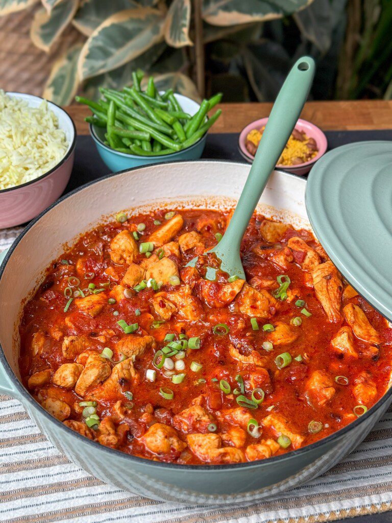 pittige kipstoof met crispy chili olie, specerijen en tomaat