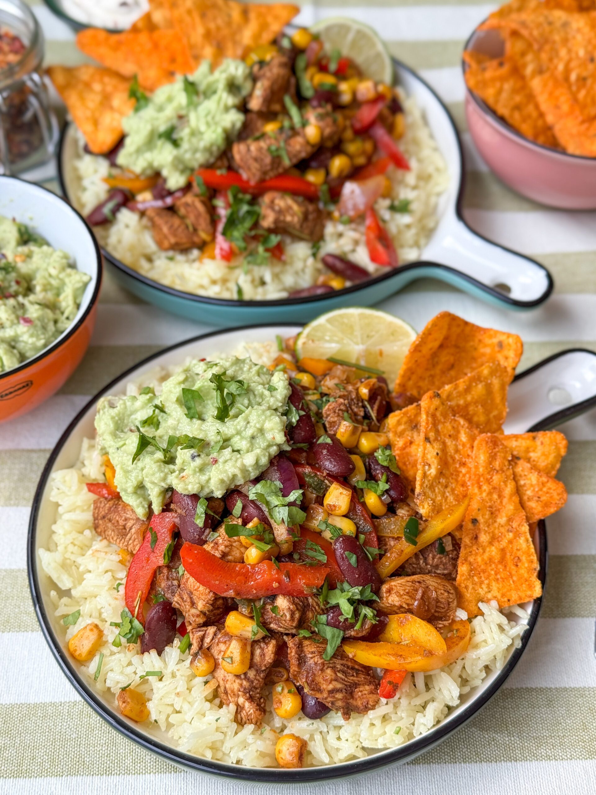 Kip fajita met rijst geserveerd met guacamole en tortillachips