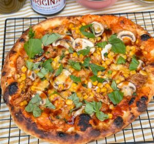 pizza met kip, BBQ saus, rode ui, mais en gesmolten kaas