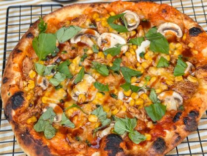 pizza met kip, BBQ saus, rode ui, mais en gesmolten kaas