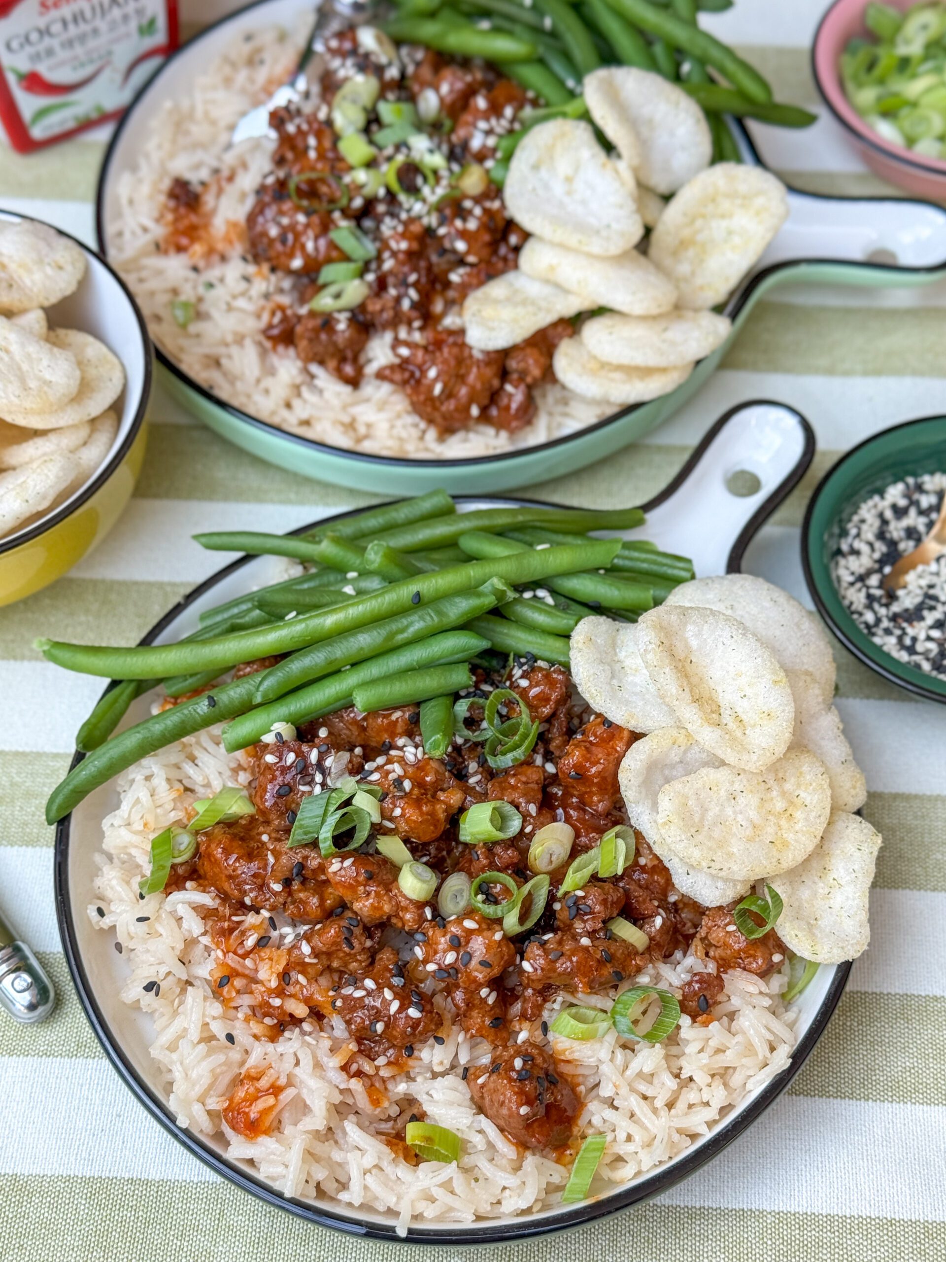 Bord met gehakt in gochujang en oestersaus met rijst, sperziebonen en kroepoek.
