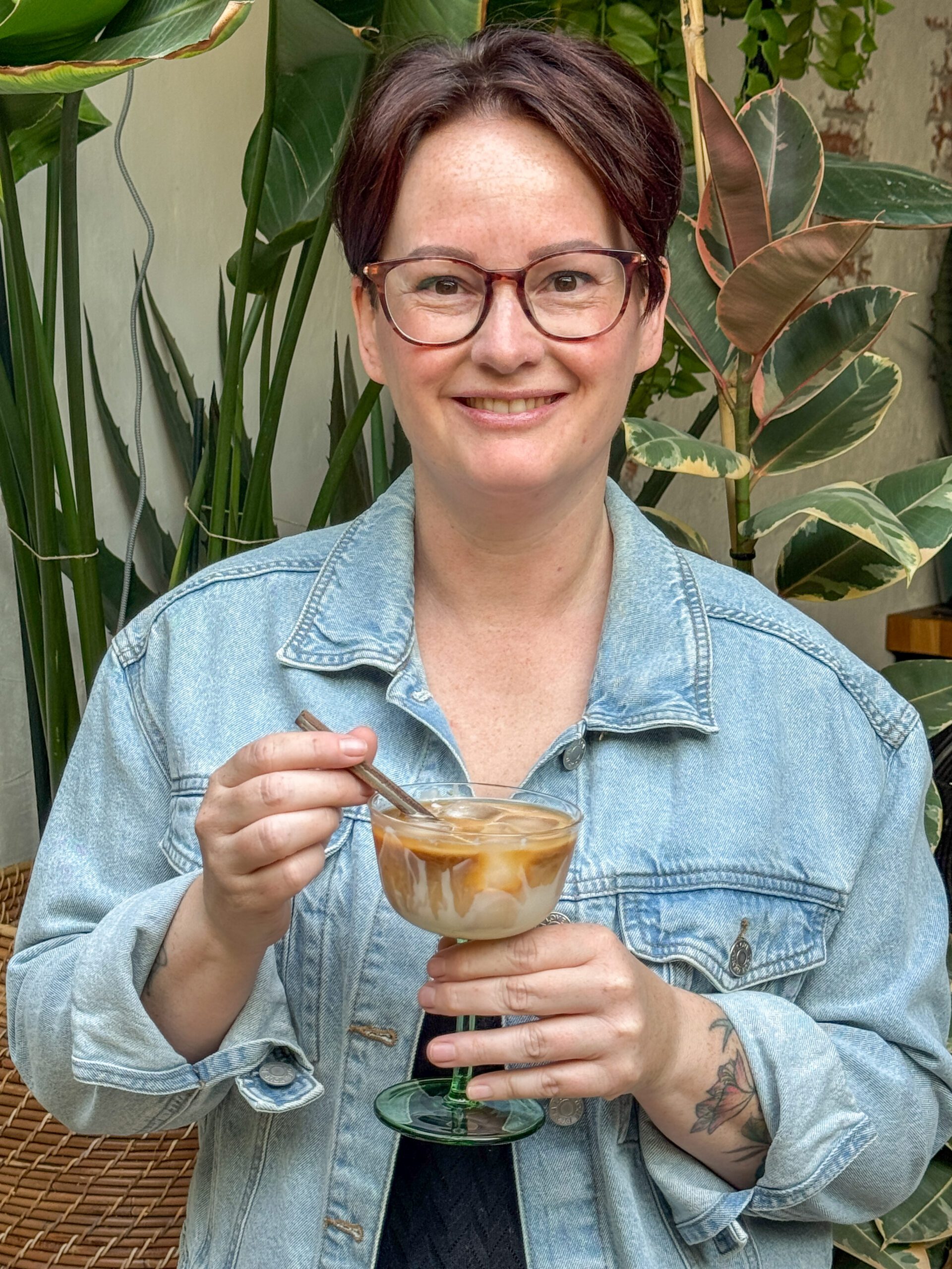 Marie Louise houdt een glas Vietnamese ijskoffie vast – romige koude koffie met gecondenseerde melk en ijs, perfect voor warme dagen.