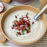 bloemkoolsoep met spekjes recept - romige soep in kom geserveerd met peterselie en krokant spek