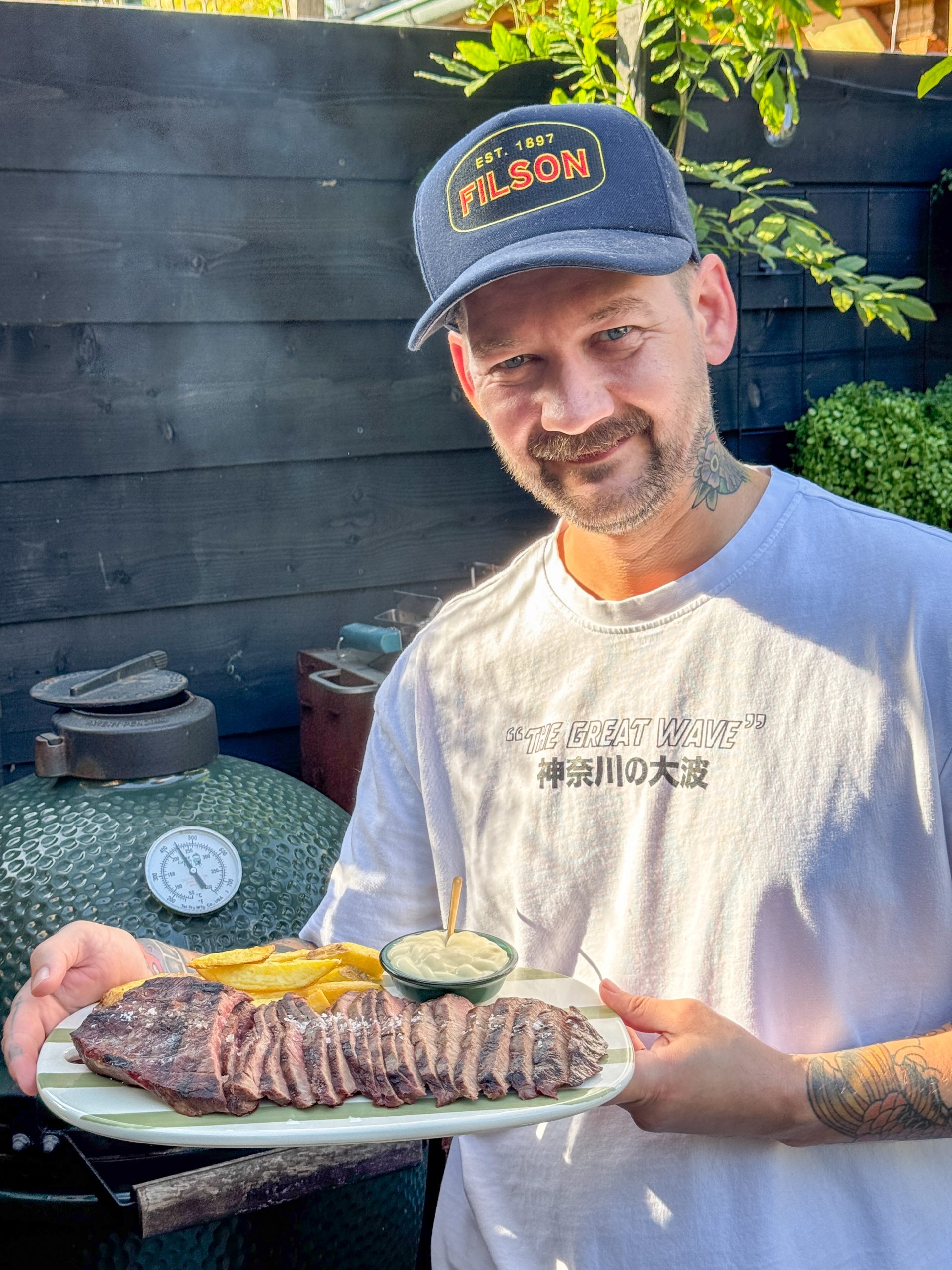 Jan Willem serveert flat iron steak van de bbq met friet