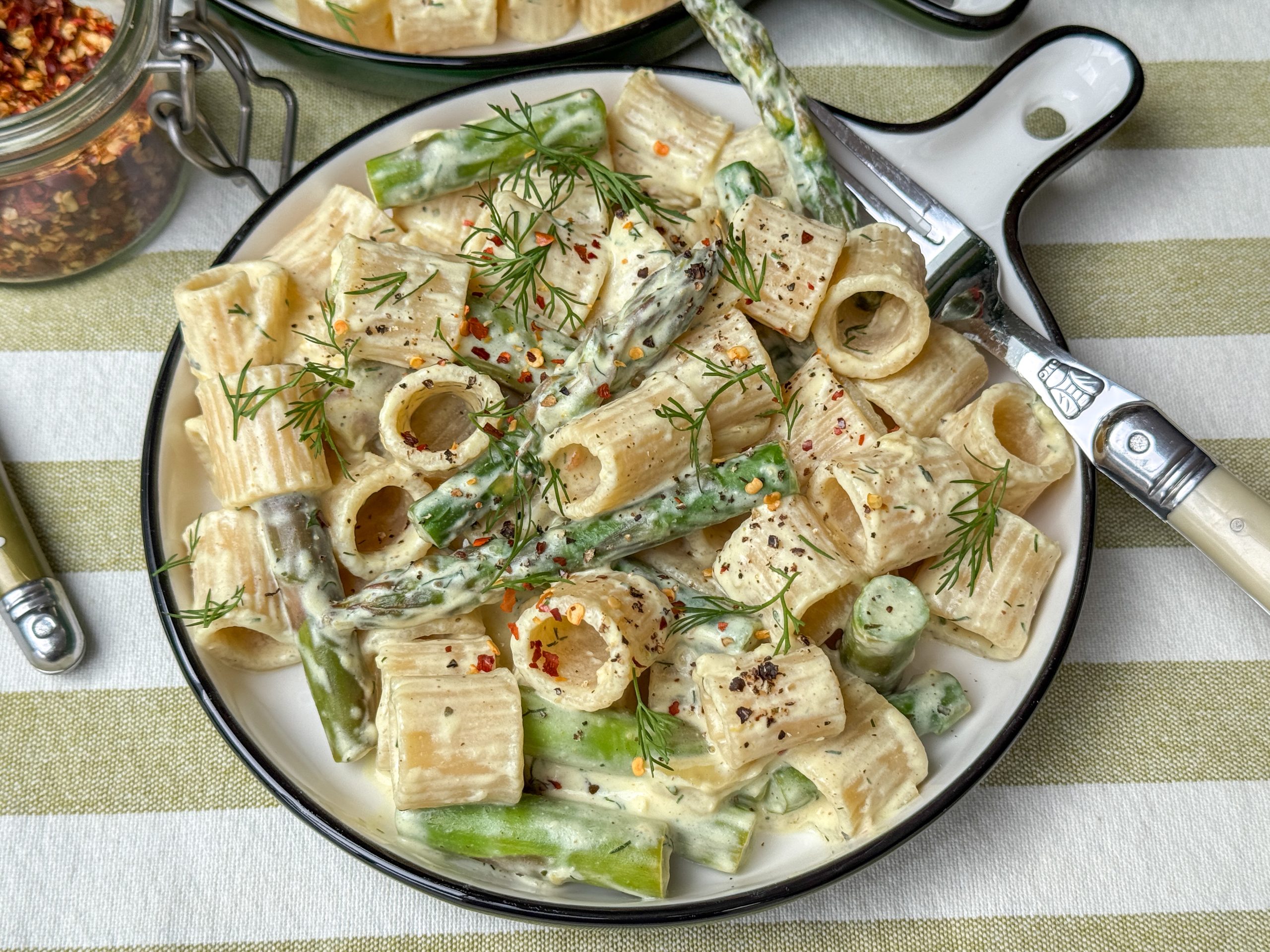 pasta met groene asperges, citroen en dille op rond bord