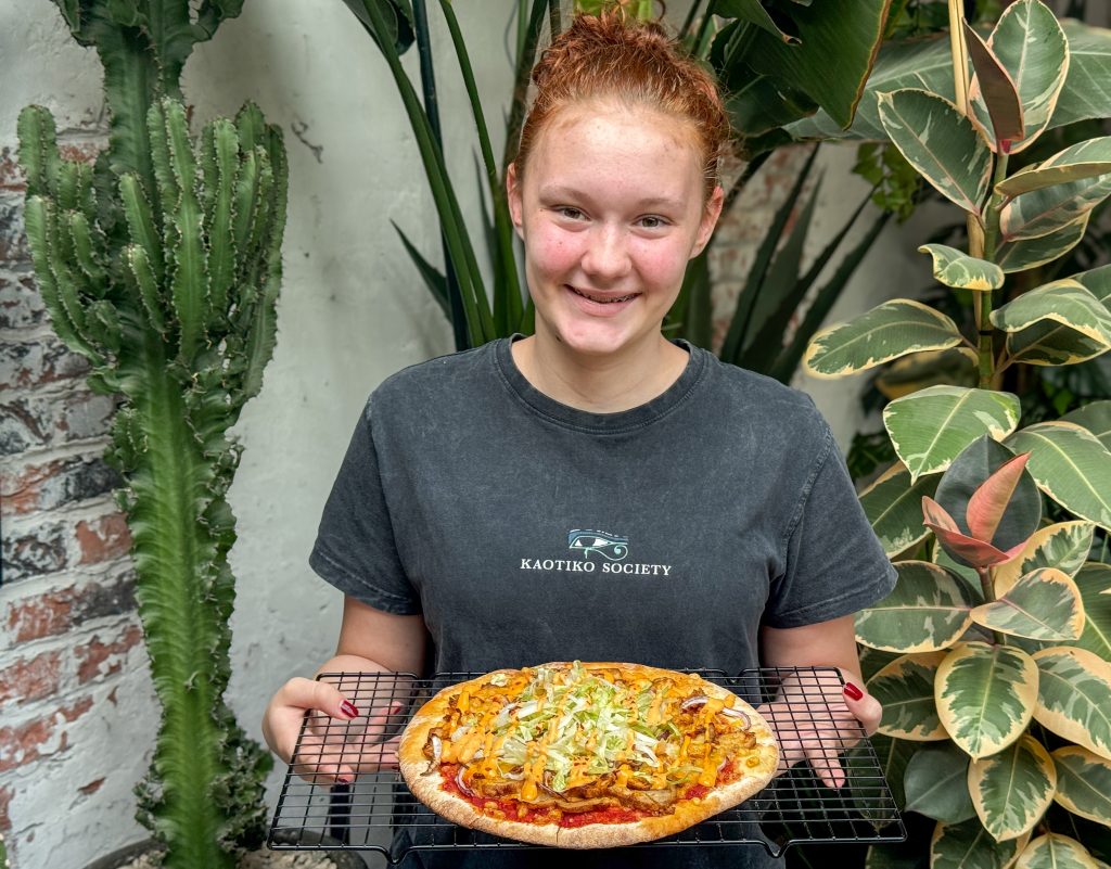 Amaranthe houdt pizza kip kebab met bang bang saus vast op rooster