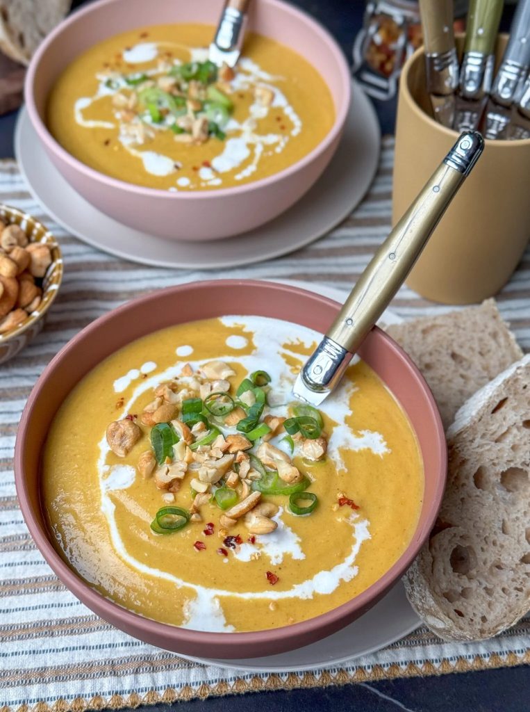 bloemkoolsoep met gele curry, kokosmelk en zoete aardappel. Afgetopt met bosui en chilivlokken