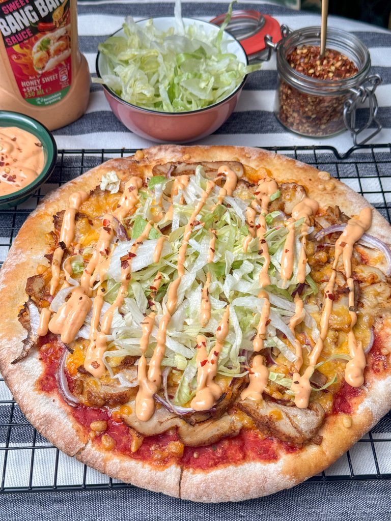 pizza kip kebab met rode ui, gesmolten tex mex kaas belegd met ijsbergsla en bang bang saus