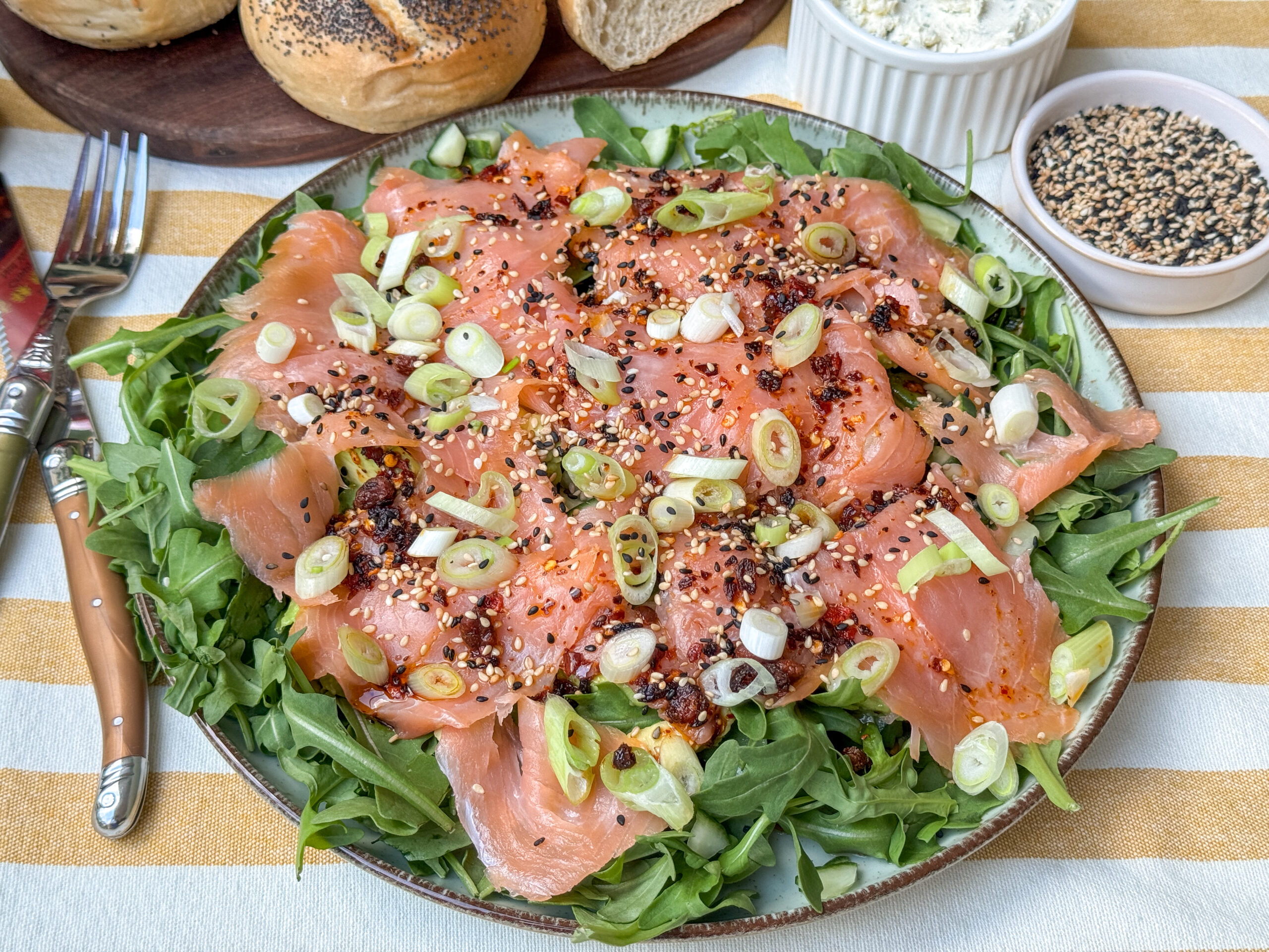 Zalm carpaccio met Aziatische dressing geserveerd met rucola en bosui