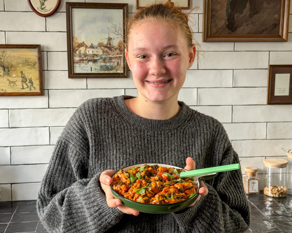 Amaranthe met bord romige orzo in tomatensaus