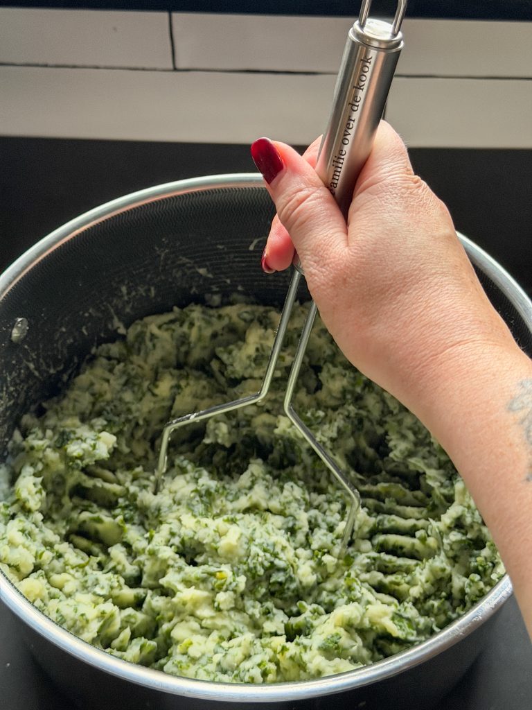 aardappelen en boerenkool worden gestampt tot een romige stamppot