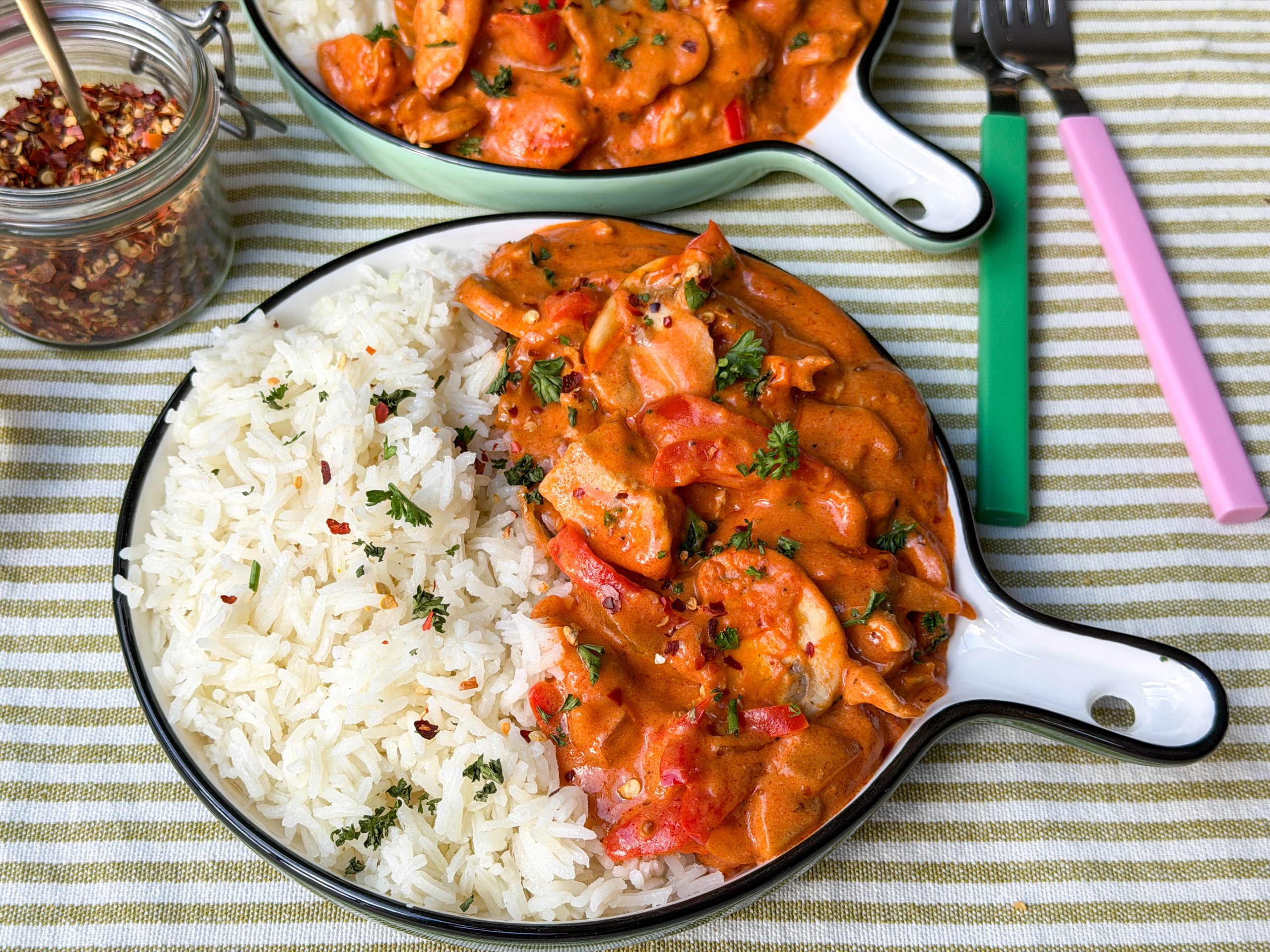 kip stroganof met paprika en champignons geserveerd met rijst op rond bord