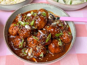 Koreaanse gehaktballetjes in gochujang saus met sesamzaad en bosui in kommetje