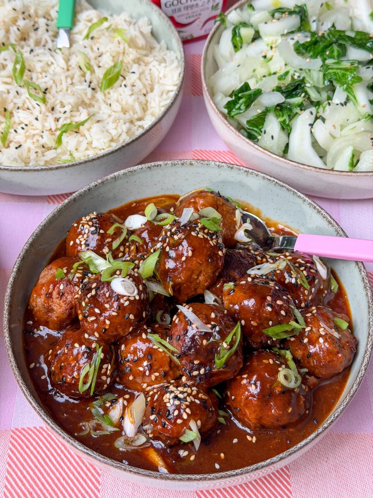 Koreaanse gehaktballetjes in gochujang saus geserveerd in kom met bosui en sesamzaadjes