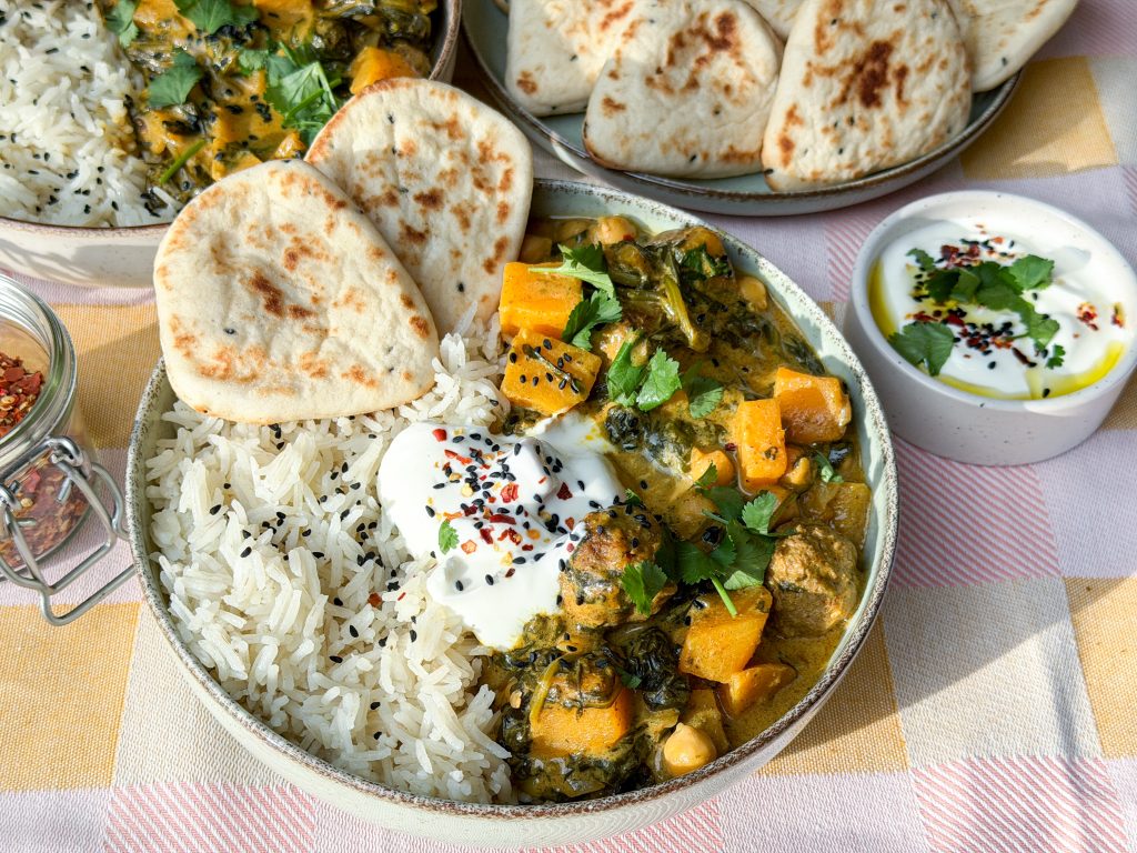 Pompoencurry met spinazie en gehaktballetjes geserveerd met rijst, naan en yoghurt