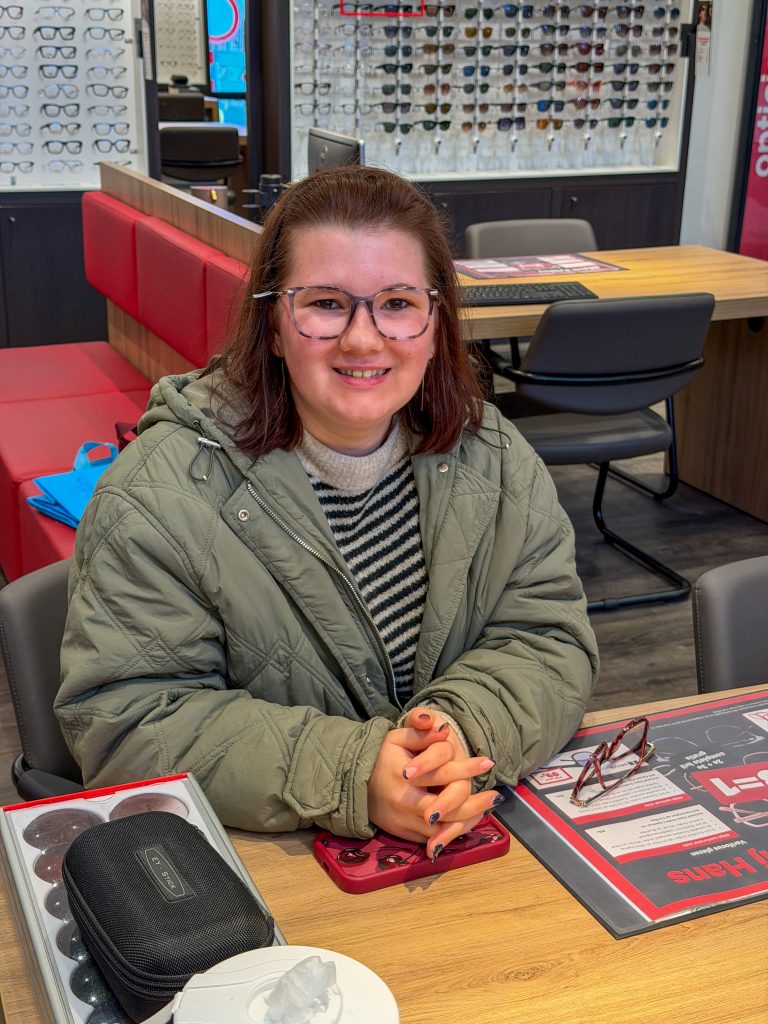 Beaudine zit bij de opticien en past een nieuwe bril.