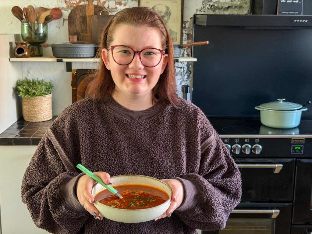 Beaudine met kom Chinese tomatensoep met kip in de keuken