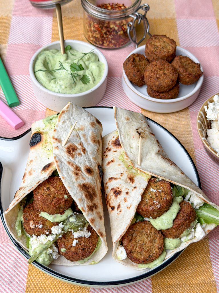 twee wraps met falafel, avocadoyoghurtdip en feta twee op rond bord