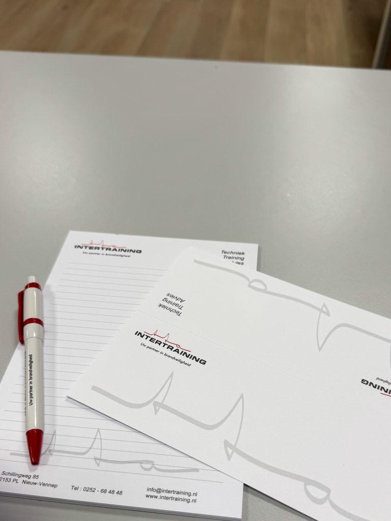 Notitieblok en pen van Intertraining op een tafel tijdens de theorie- en veiligheidstraining.