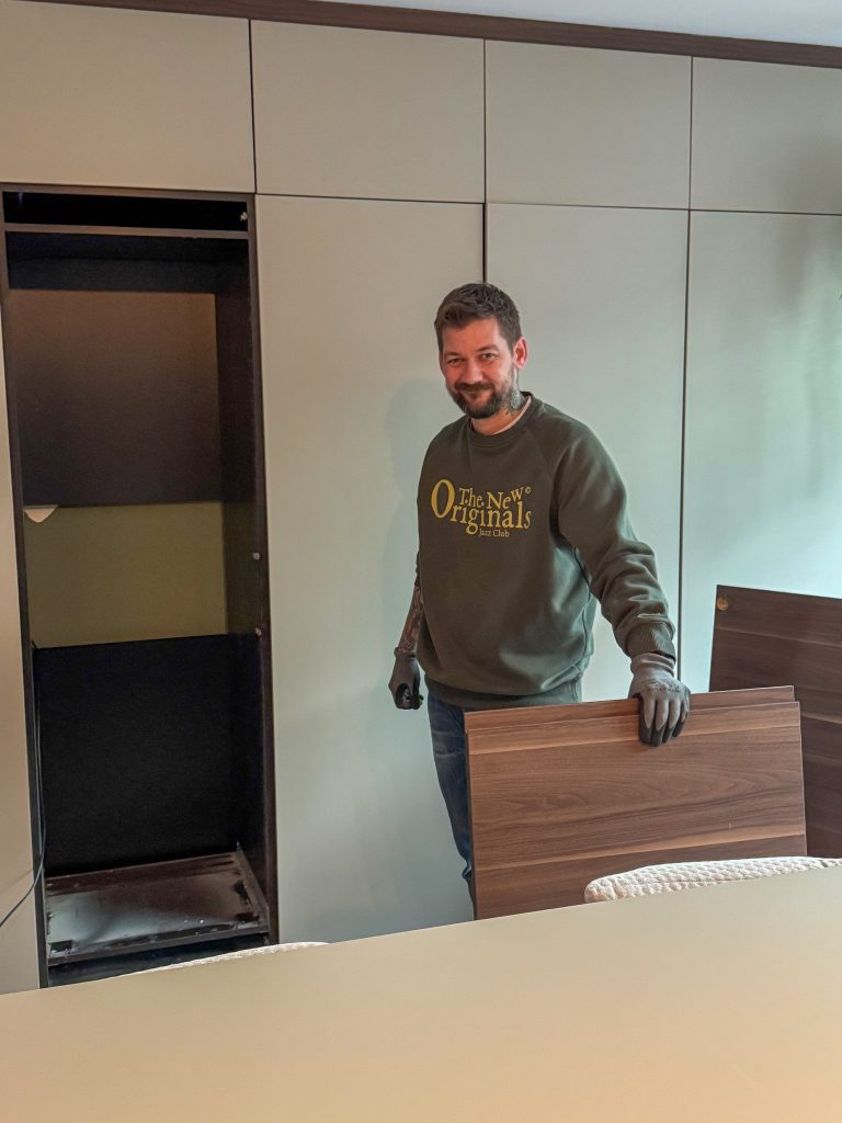 Jan Willem plaatst het nieuwe koelkastfront in de keuken.