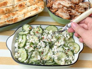 komkommer salade met feta wordt opgeschept met een vork uit groene schaal