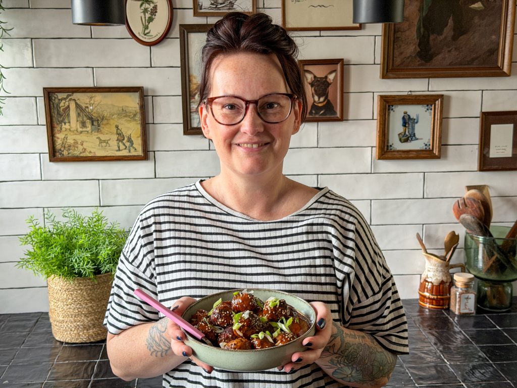 Marie Louise in de keuken met een schaal Koreaanse gehaktballetjes in gochujangsaus uit weekmenu 46