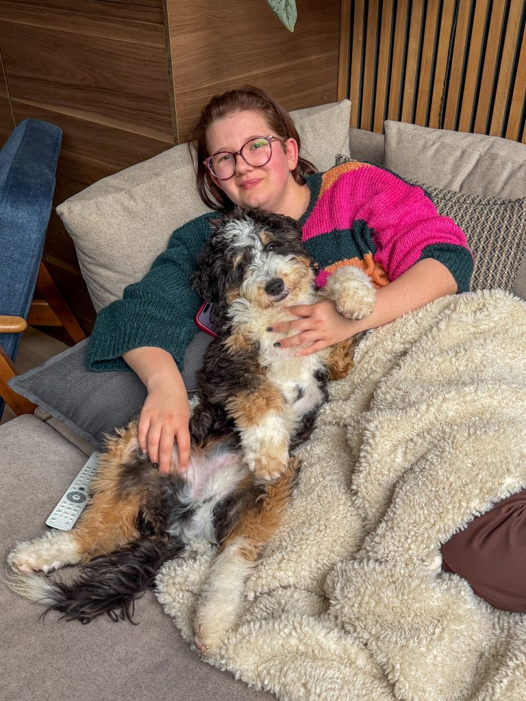 Beaudine ligt op de bank met bernedoodle legend
