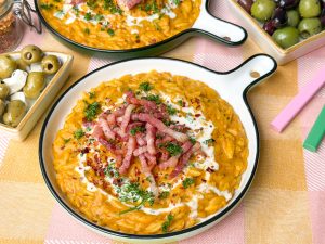 orzo met pompoen en krokante spekjes op rond bord met peterselie en kookroom