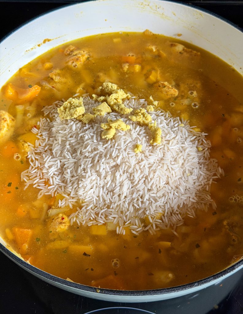 Basmati rijst en bouillonblokje verkruimeld toevoegen