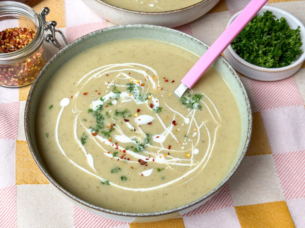 romige witlofsoep in groene kom met kookroom