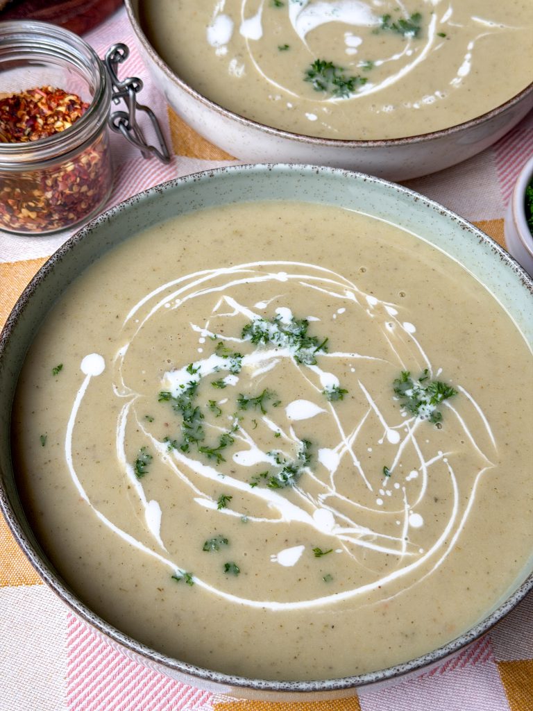 romige witlofsoep in kom met peterselie en roomswirl