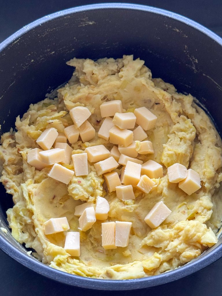 Blokjes kaas toevoegen aan stamppot