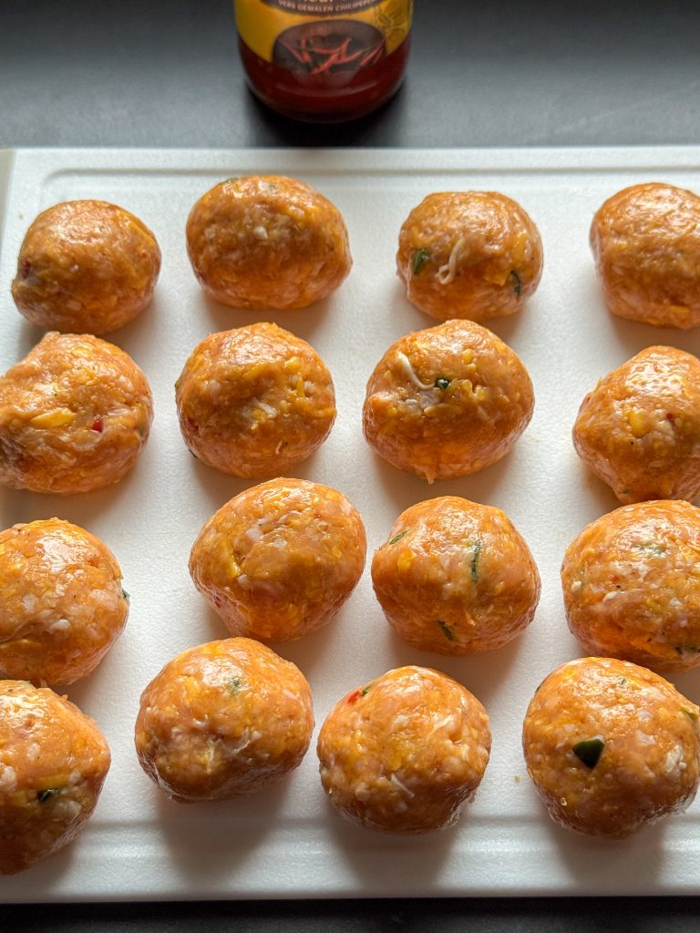 Ronde, ongebakken balletjes op een snijplank voordat ze de pan in gaan