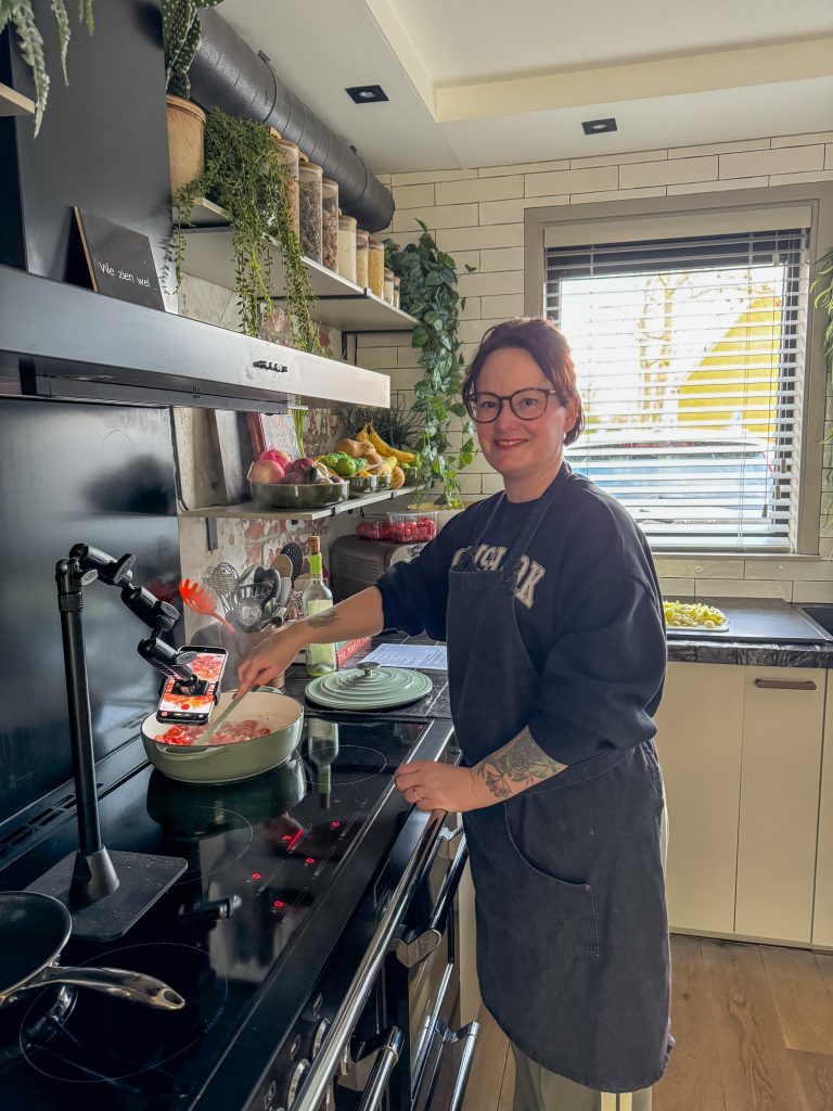 Thuis bij familie over de kook: week 49. Marie-Louise staat te koken aan het fornuis terwijl ze een recept video opneemt.
