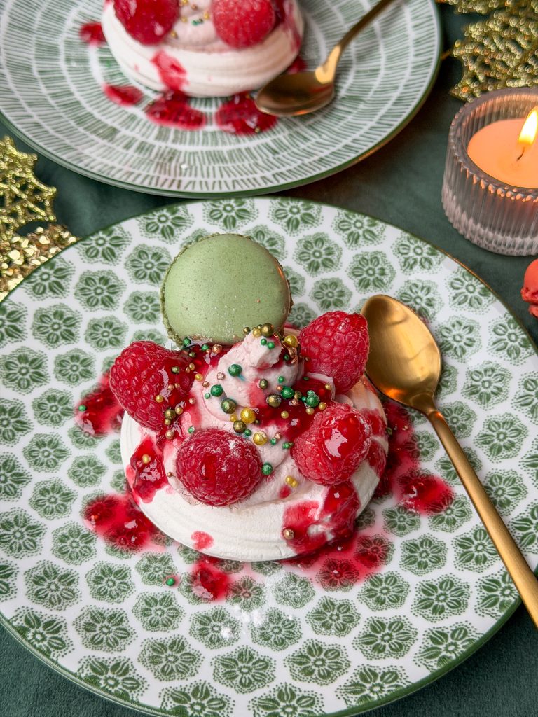 pavlova met frambozen, mascarpone en groene macaron op feestelijk bord