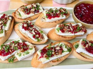 Bruschetta met brie en cranberry compote geserveerd op plank, makkelijk recept