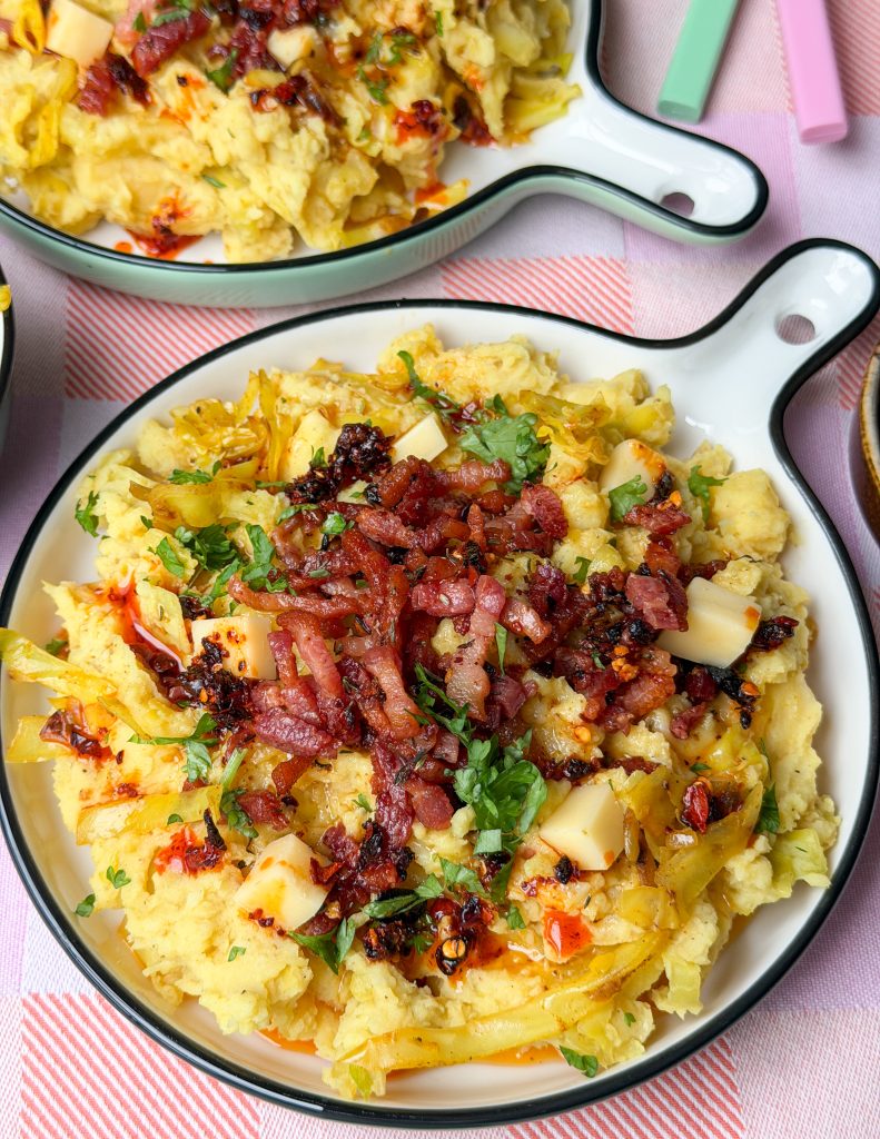 Stamppot spitskool geserveerd met spekjes en kruiden