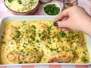 Peterselie over de witlof met ham en kaas ovenschotel strooien