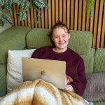 Amaranthe aan het werk op de laptop op de bank